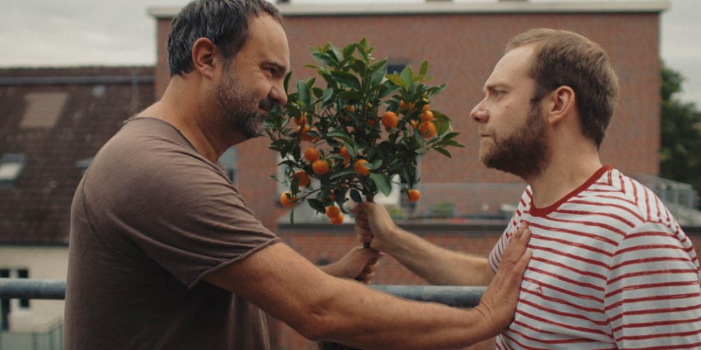 Zwei Männer mit Orangenbaum