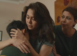 “Banu”: Wer kann im Patriarchat gewinnen? Auf dem Bild sieht man drei Personen, zwei Frauen und einen kleinen Jungen. Sie sitzen sehr nah beieinander. Die Mutter (Banu) umarmt den Jungen (Ruslan) zärtlich. Neben ihr sitzt ihre Mutter und schaut sie besorgt an.