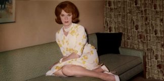 Frau posiert im Kleid auf einem Sofa