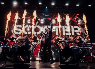 Zwischen Bandzoff und Partyparolen: Kein Platz für Tiefe in Scooter-Doku FCK 2020 – Zweieinhalb Jahre mit Scooter, Leadsänger srpingt vor feurigem Bühnenbild neben Tänzerinnen in die Luft