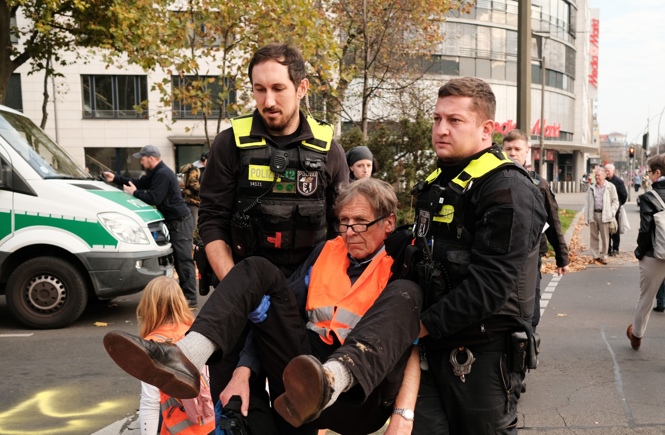 Zwei Polizisten tragen einen Aktivisten der Gruppe "Letzte Generation" wird von einer Strassenblockade weggetragen
