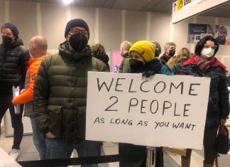 Weniger private Unterkünfte für Ukraine-Flüchtlinge Menschen stehen an einem Bahnhof und halten ein Schild für Geflüchtete aus der Ukraine hoch.