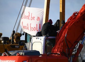 Besetzung von Gaspipeline aufgelöst Auf dem Foto sieht man eine Baumaschine., auf der zwei Personen sitzen. Ein Transparent hängt daneben, darauf steht "Don't be a fossil fool". Die Besetzung der Gaspipeline wurde aufgelöst.. Foto: Jonas Walzberg/dpa