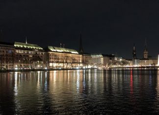 Energiekrise: Boulevard in der Dämmerung Gebäude am Wasser vor dunklem Himmel