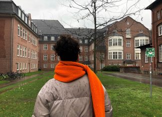 Was machen die orangenen Schals an den Bäumen? Eine Frau trägt einen orangenen Schal als Zeichen der Solidarität für Armut und Obdachlosigkeit