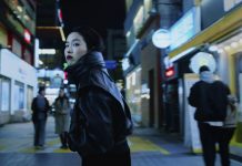 „Ohne Rückkehr“: Pokerface auf Identitätssuche Ohne Rückkehr: Protagonistin Freddie dreht sich in beleuchteter Einkaufsstraße um und trägt eine schwarze Lederjacke