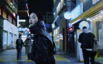 „Ohne Rückkehr“: Pokerface auf Identitätssuche Ohne Rückkehr: Protagonistin Freddie dreht sich in beleuchteter Einkaufsstraße um und trägt eine schwarze Lederjacke