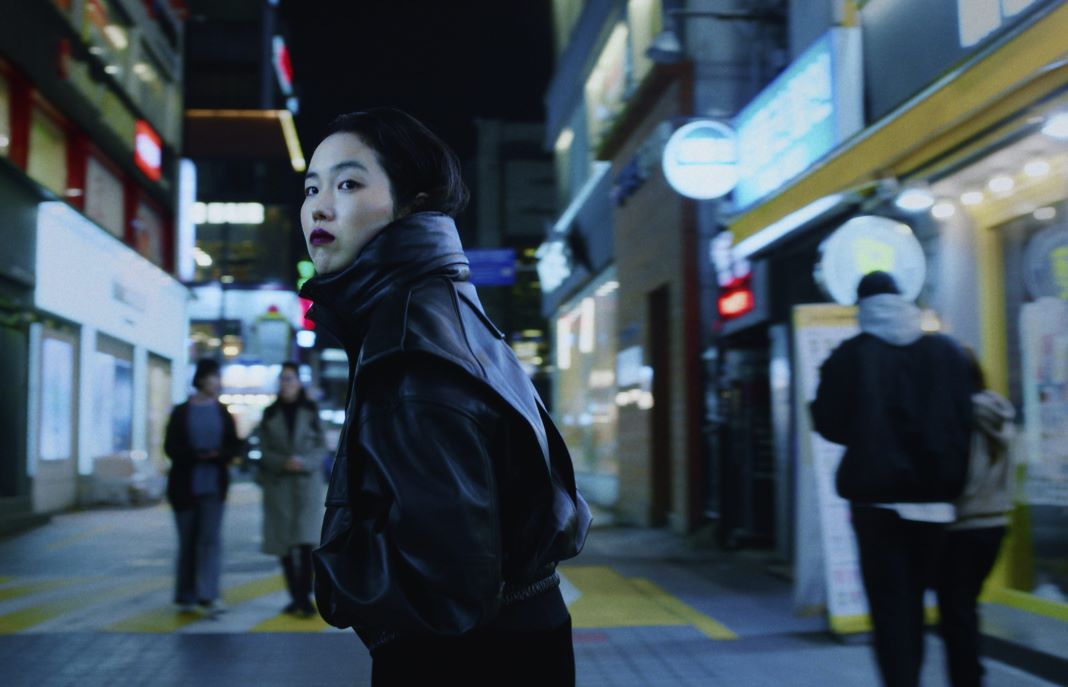 Ohne Rückkehr: Protagonistin Freddie dreht sich in beleuchteter Einkaufsstraße um und trägt eine schwarze Lederjacke