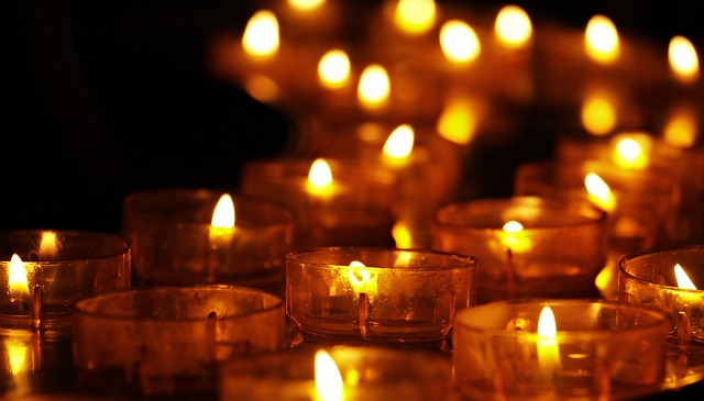 Viele brennende Kerzen in einer Kirche. Um Energie zu sparen, reduzieren viele Kirchen Beleuchtungen oder drehen Heizungen runter.