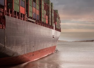 Fachkräftemangel an deutschen Reedereien Ein Containerschiff im Sonnenaufgang. Deutsche Reedereien sind fast voll ausgelastet.