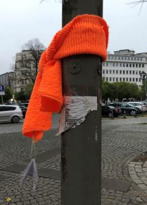 Ein orangener Schal hängt an einer Laterne und ist bereit zum Pflücken. 