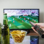 Öffentlich-rechtliches Eigentor Ein Flachbildfernseher auf dem ein Fußball-Spiel läuft. Auf dem Couchtisch stehen zwei Bierflaschen und eine Schale mit Chips. ARD und ZDF zeigen Spiele der Fußball-WM in Katar.
