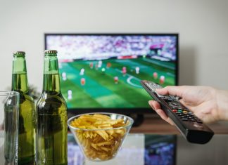 Öffentlich-rechtliches Eigentor Ein Flachbildfernseher auf dem ein Fußball-Spiel läuft. Auf dem Couchtisch stehen zwei Bierflaschen und eine Schale mit Chips. ARD und ZDF zeigen Spiele der Fußball-WM in Katar.