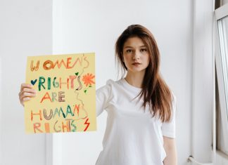 Internationaler Tag gegen Gewalt an Frauen Eine Frau, die gegen Gewalt an Frauen protestiert. Sie hält ein Schild mit der Schrift "Womens Rights are Human Rights" hoch.