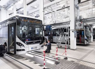 Neues Assistenzsystem der VHH-Busse schützt Radler und Fußgänger Die Buswerkstatt ist hell beleuchtet und mehrere Arbeiter reparieren einen Bus.