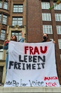 Zwei Frauen mit einem Banner "Frau Leben Freiheit" auf einem Iran-Protest in Hamburg. 