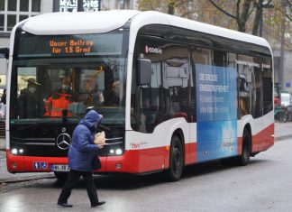 Umstieg auf Elektrobusse in Hamburg verlangsamt sich E-Bus (Elektrobus) auf einer Straße vor einem Menschen