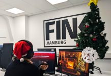 Unsere liebsten Weihnachtssongs Weihnachtssongs : Lieblinge der FINK-Redaktion. Redakteurin Sarah Böse sitzt am Computer mit Kopfhörern an, im Hintergrund ein Weihnachtsbaum und das FINK.HAMBURG Logo auf einer Wand.