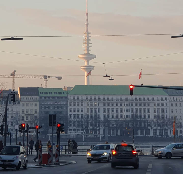 Das Foto zeigt Autos, die an roten Ampeln stehen, im Hintergrund ist der Fernsehturm in Hamburg zu sehen.
