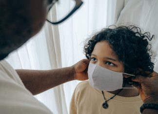 RS-Virus belastet Hamburgs Kinderkliniken Ein Arzt zieht einem Kind eine Maske auf. RSV Virus belastet Hamburger Kinderkliniken.