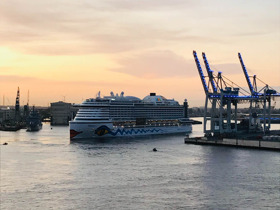 Ein Kreuzfahrtschiff der Aida Cruises fährt aus dem Hamburger Hafen aus. Foto: Unsplash/ Aron Schmitz