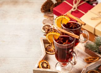 Glühwein für zu Hause – wie auf dem Weihnachtsmarkt Glühwein - zwei Becher Glühwein stehen auf weihnachtlich dekoriertem Tisch mit Geschenken