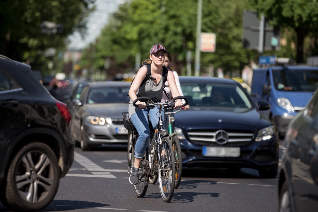 Fahrrad fahren in Hamburg: Eine Radfahrerin fährt zwischen vielen Autos