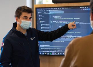 Volkshochschulkurse in Hamburg: Stadt will wieder stärker bezuschussen Mann mit Mundschutz zeigt auf Bildschirm und erklärt etwas.