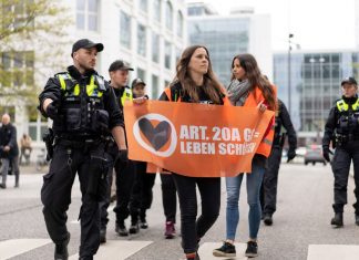 Razzia bei der Letzten Generation auch in Hamburg Zwei Aktivistinnen der Letzten Generation werden von Poliziei Beamten begleitet