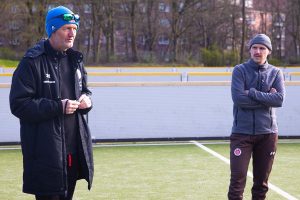 Links steht Cheftrainer Wolf Schmidt bei der Ansprache an die Mannschaft. Rechts steht Co-Trainer Jonas Dawid.