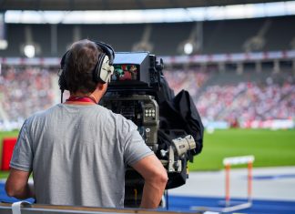 In Hamburg sagt man Tschüss: Keine Frauen-Fußball-WM im TV? Ein Mann bedient eine TV-Kamera am Spielfeldrand eines Fußballspiels. Man sieht den Mann von hinten und guckt mit Blickrichtung der Kamera