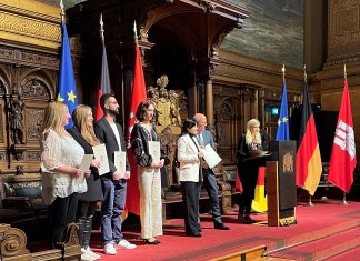 Deshalb steigt die Zahl der Einbürgerungsanträge in Hamburg Peter Tschentscher steht neben den neuen Staatsbürgern. Die Neubürger halten ihre Einbürgerungsurkunden in den Händen.