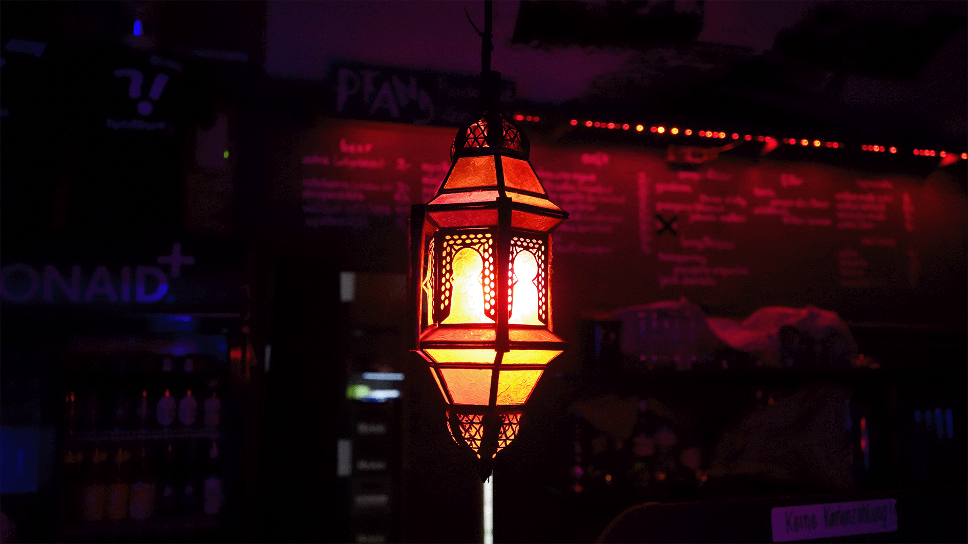 Gedämpftes oranges Licht von einer Deckenlampe aus Glas in einer Bar.