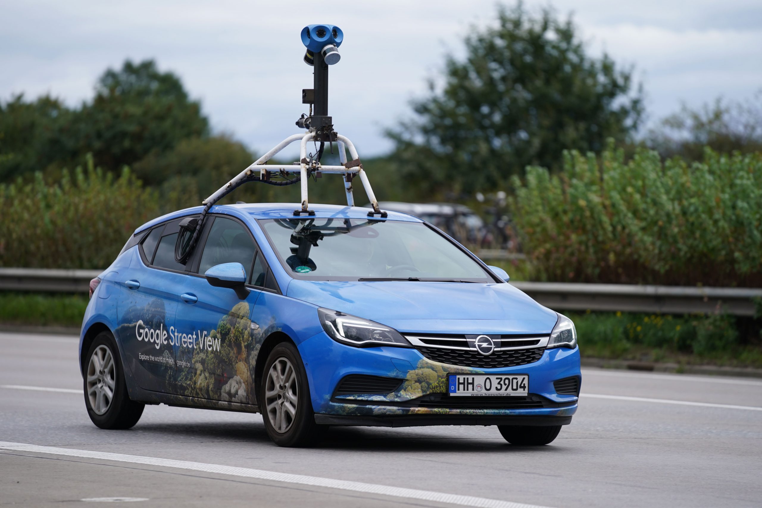 Google Streetview Fahrzeug mit Kamera auf dem Dach fährt auf einer Straße