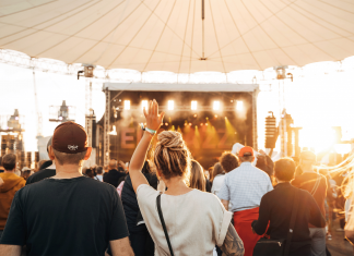 Tipps für ein sonniges Wochenende im Juni Festivalbesucher*innen werden bei Sonnenschein von hinten fotografiert mit dem Gesicht zur Bühne.