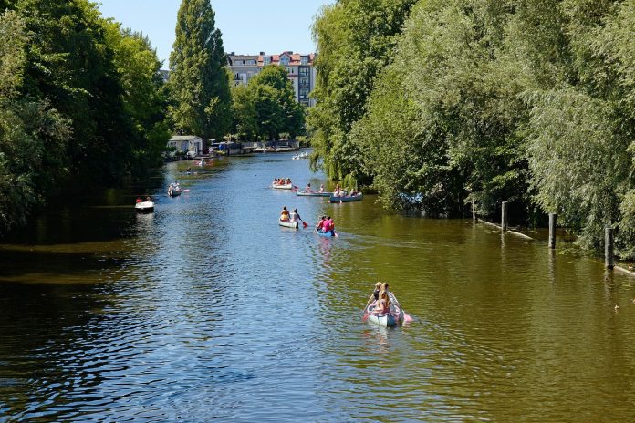 Auf dem Kanal in Hamburg paddeln Personen im Sommer.