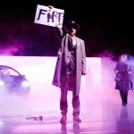 Rezension: „Barocco“ – ein Spiel mit dem Feuer Umgeben von Nebelschwaden steht Odin Biron für die Inszenierung „Barocco” auf der Bühne. Demonstrativ hält er ein Plakat in die Luft auf dem „Fire“ steht.