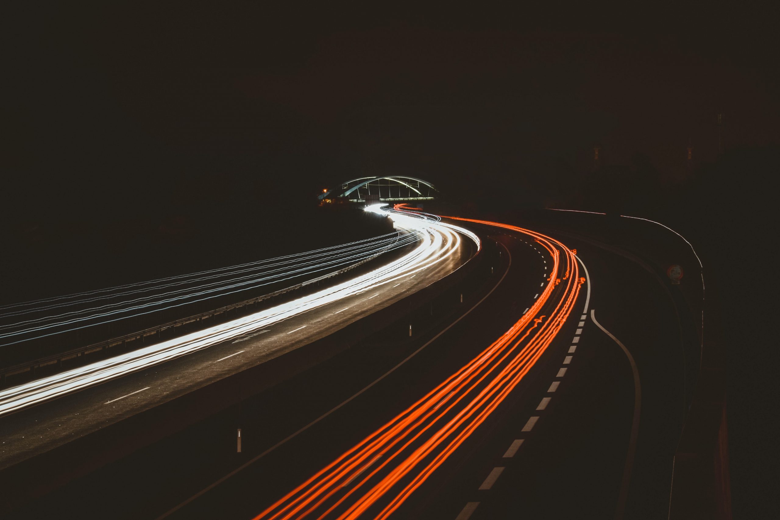 Autos fahren auf einer Autobahn bei Nacht.