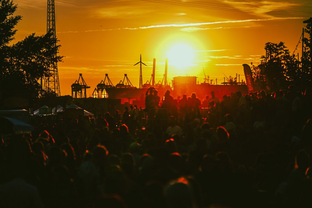 Auf dem Dockville Festival geht vor dem Hafen die Sonne unter.