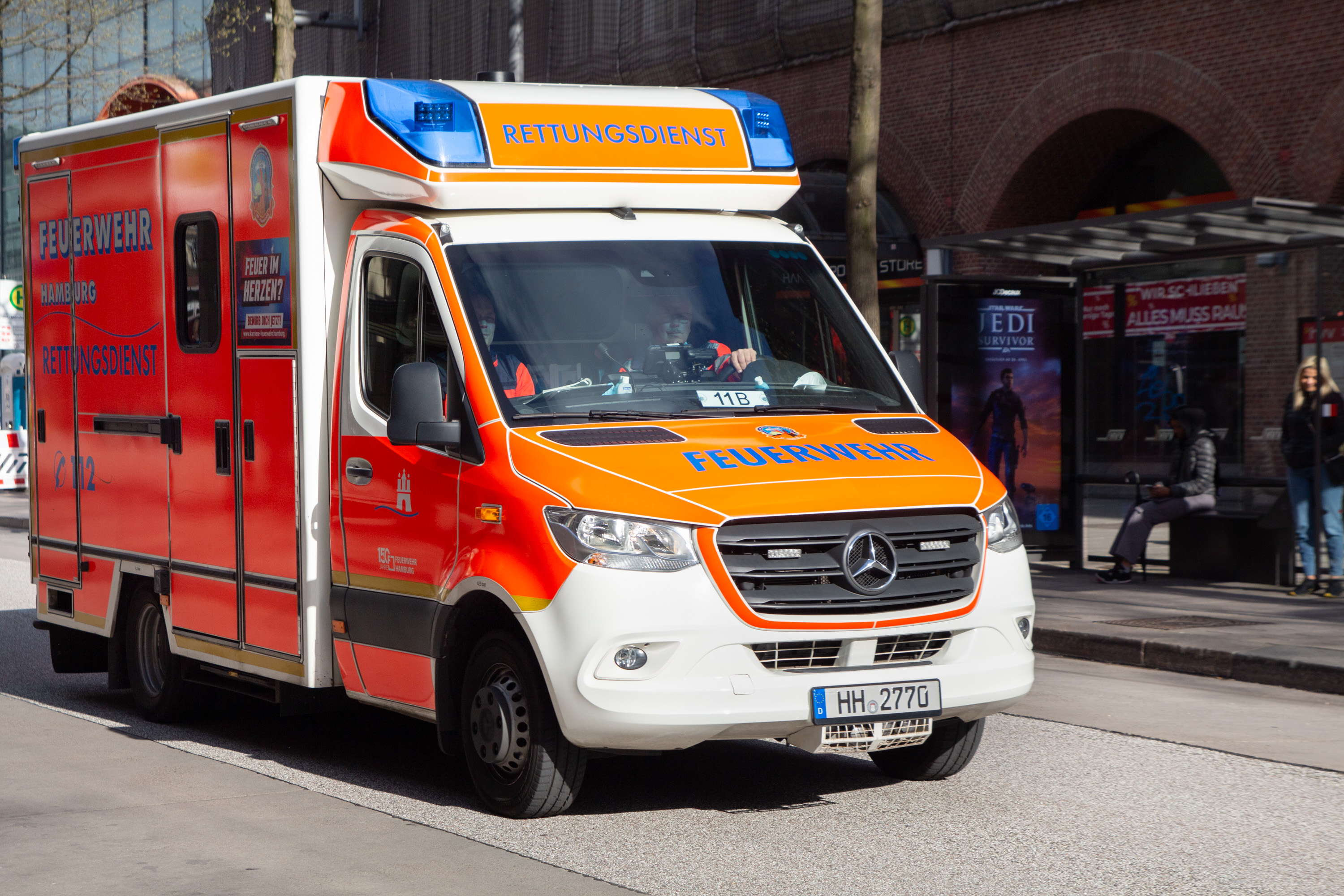 Ein orangener Rettungswagen fährt über die Mönckebergstraße.