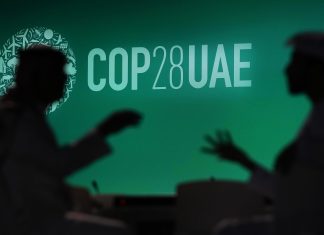 COP28: Weltklimakonferenz in Dubai startet Zwei Menschen unterhalten sich vor einem Logo des UN-Klimagipfels COP28. Bei dem COP28-Treffen wollen mehr als 190 Länder ab Donnerstag am Persischen Golf die erste große Bestandsaufnahme der Umsetzung der Pariser Klimakonferenz 2015 erstellen.
