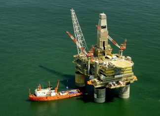 So viele Lobbyisten für fossile Brennstoffe bei COP28 wie noch nie Eine Bohrinsel mit Boot im Meer.