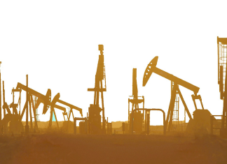 Saudi-Arabien positioniert sich offen gegen fossilen Energieausstieg Türme und Aufbauten einer Raffinerie ragen vor einem diesig gelben Hintergrund in die Höhe.