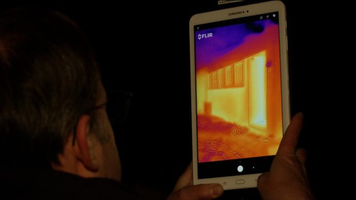 Haus wird auf einer Thermo-Tour mit einer Wärmebildkamera gefilmt