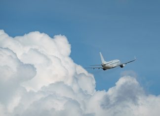 Flughafen Hamburg tritt Wasserstoff-Netzwerk bei Ein Flugzeug lässt eine weiße Wolkendecke hinter sich und steigt nach oben.