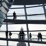 Wie gut ist Deutschland wirklich beim Klimaschutz? Innenansicht des deutschen Bundestages. Menschen gehen auf den Gängen der Kuppel.