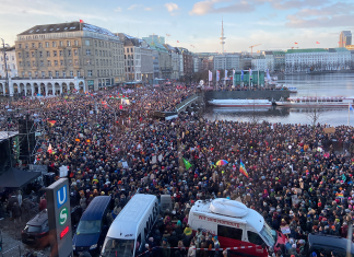 Demo gegen Rechtsextremismus am Sonntag Eine große Menschenmenge steht am Jungfernstieg. Man sieht viele unterschiedliche Flaggen.