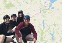 Mit dem Fahrrad an die Ostsee Im Hintergrund eine Karte mit rot eingezeichneter Route von Hamburg nach Travemünde. Im Vordergrund unten links im Bild eine Gruppe von vier jungen Menschen in Fahrradklamotten mit Helmen, die in die Hocke gehen.