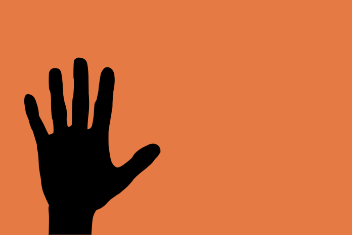 Symbolbild: Hasskriminalität Hamburg. Eine ausgestreckte Hand vor orangenem Hintergrund