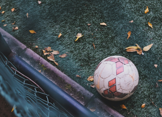 Baller League: Das musst du über die neue Fußballiga wissen Ein Fußball liegt auf dem Boden vom einem Kunstrasenfußballplatz. Ein paar braune BLätter von einem baum liegen auf dem Boden, um den Ball herum und ein Geländer ist zu sehen. Das Bild ist aus der Vogelperspektive aufgenommen.